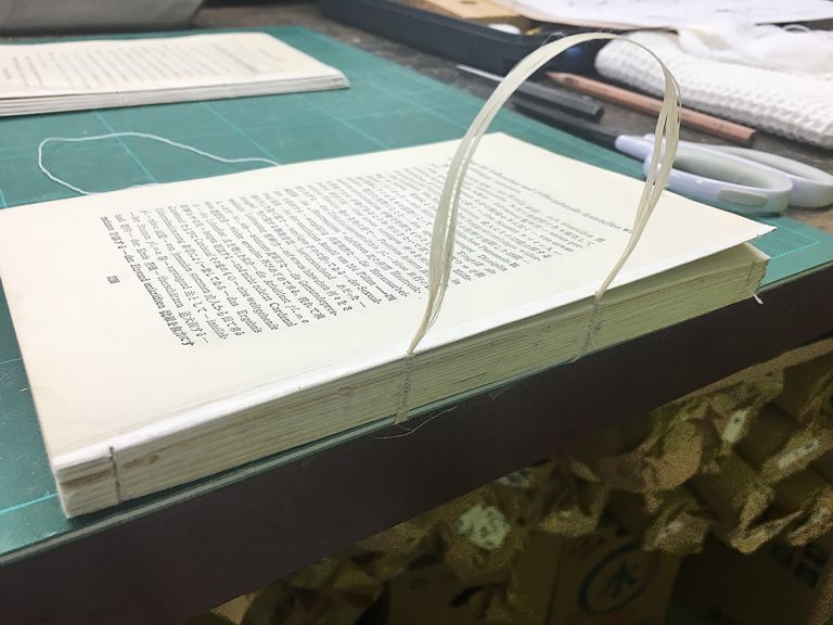 ③ 糸綴じ直し：全頁の糸を外し、麻糸にて綴じ直します。